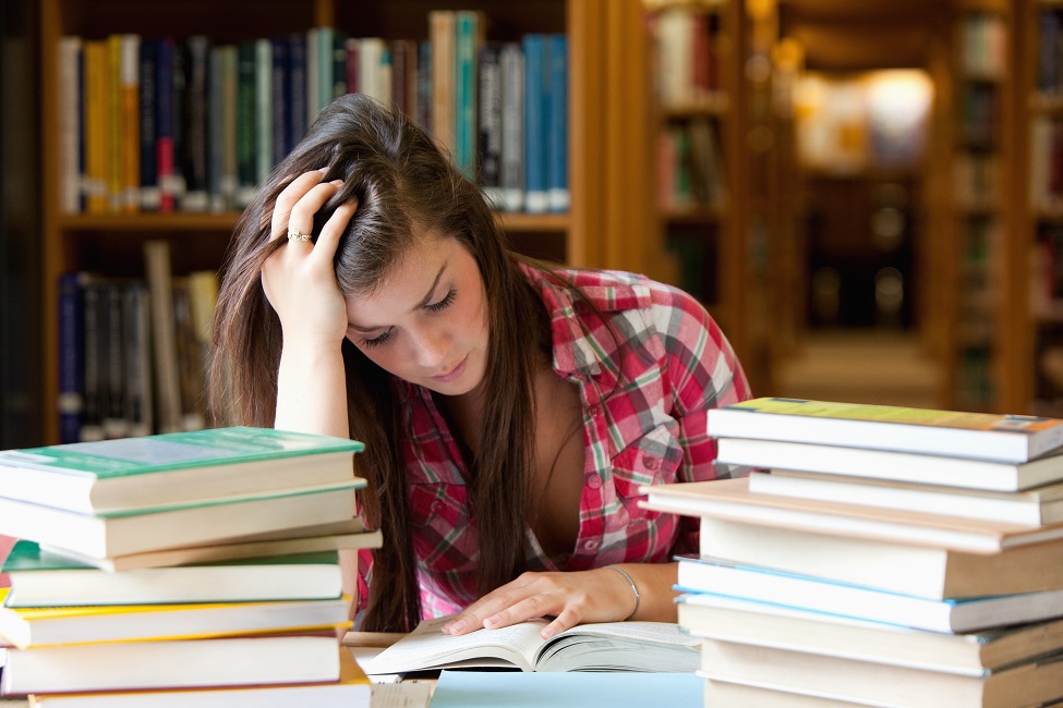 Female stressed with a pile of books