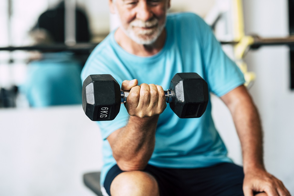 An elderly man doing bicep curls