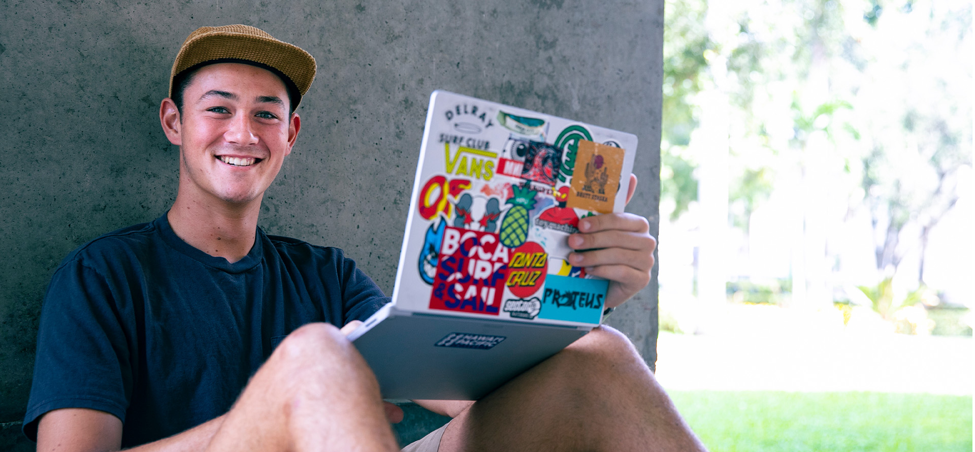 Student with laptop smiling