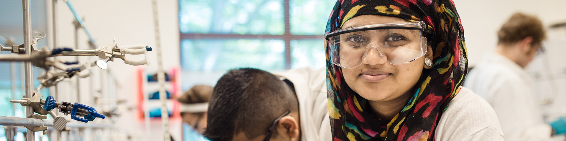 Student in a biology lab smiling at the camera