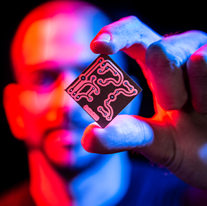 A male person holding up a microchip