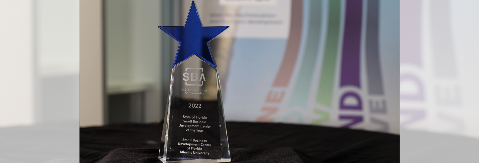 SBA acrylic award with blue star on top on abstract colorful background